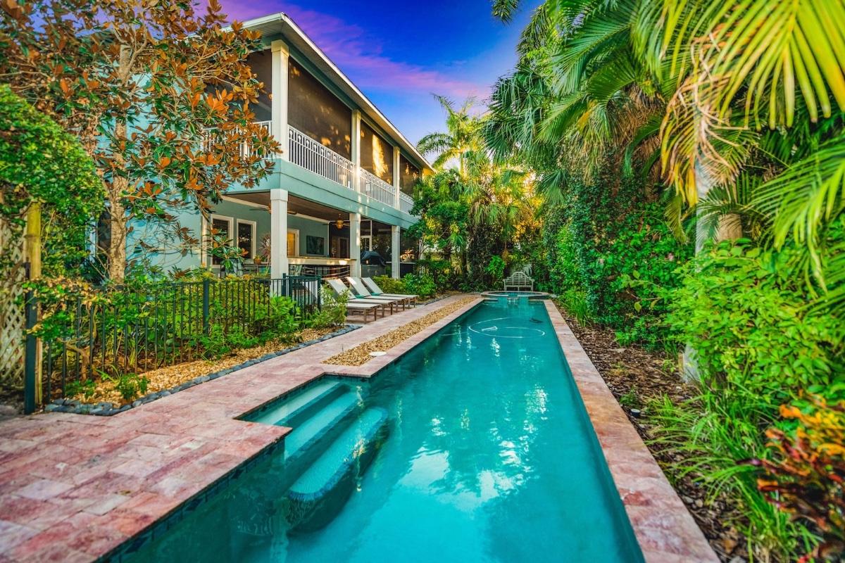 A luxurious private pool surrounded by beautiful palm trees and tropical landscaping. All of the private pools at Once Upon a Beach vacation rentals are heated.